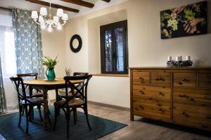a dining room with a table and chairs and a dresser at La Masia de Rendé Masdéu in Espluga de Francolí