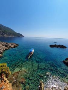 a boat in the water next to a rocky coast at Ceneviz Hotel in Adrasan