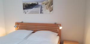 ein Schlafzimmer mit einem Bett und einem Bild eines Piers in der Unterkunft Ferienwohnung 4 im Haus am See mit Wintergarten und Terrasse in Seedorf + 55 Fotos