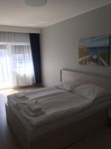 a large bed in a bedroom with a window at Apartament Silence Baltic Skandynawski in Pobierowo