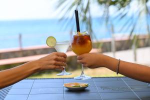2 personnes prennent des boissons sur une table dans l'établissement Villaggio Stella del Sud & Resort, à Pisciotta