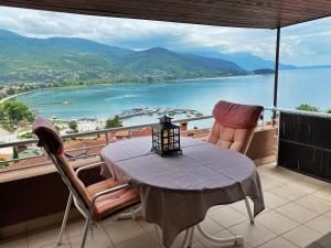 einen Tisch und Stühle auf einem Balkon mit Blick auf das Wasser in der Unterkunft Lakeview Apartments Ohrid in Ohrid