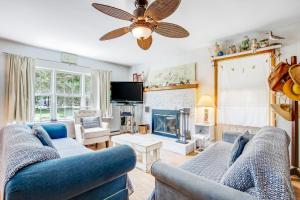a living room with two blue couches and a fireplace at The Seashell Cottage in Ocean City