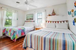a bedroom with two beds and a ceiling fan at The Seashell Cottage in Ocean City