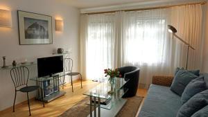 a living room with a couch and a tv at Appartements Haus Tannenburg in Ahlbeck