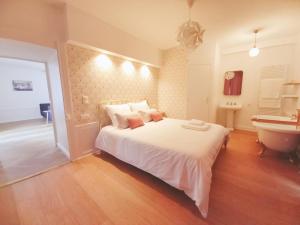 a bedroom with a bed and a tub and a sink at La Promenade - Appartement de charme avec vue sur le canal et ses écluses - Centre historique in Redon