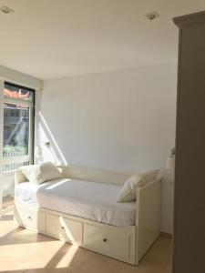 フィニステレにあるApartamento con terraza primera linea de playaの窓のある部屋にある白いベッド