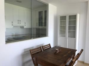 フィニステレにあるApartamento con terraza primera linea de playaの木製のテーブルと椅子のあるダイニングルーム +4枚の写真