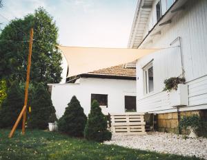 Frysztak的住宿－Domek na wsi - Fyrtokfest，遮阳篷在白色房子的前院