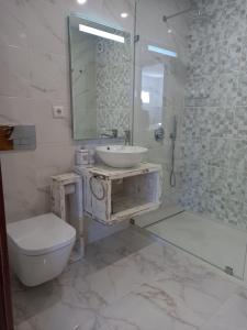 a bathroom with a sink and a toilet and a mirror at KABACEIRA VILLAGE in Atalaia