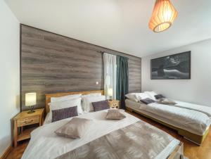 a bedroom with two beds and a large window at Plitvica River House in Plitvica selo