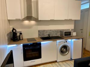 a kitchen with a washing machine and a microwave at LE VICTOR HUGO - Wifi - Centre ville - PROPERTY RENTAL NM in Périgueux