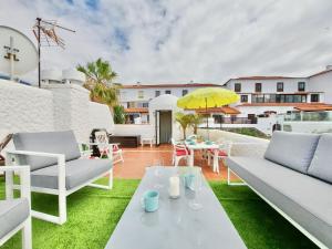 a patio with chairs and a table and an umbrella at Infinity View in Puerto de la Cruz