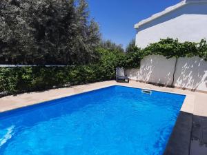 a swimming pool in front of a house at Casinha das Oliveiras in Bugios