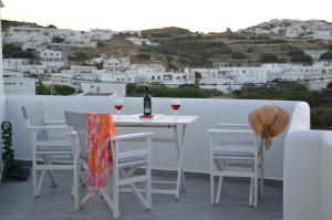 a table and chairs with wine glasses on a balcony at Rhyolite Apartment in Triovasálos