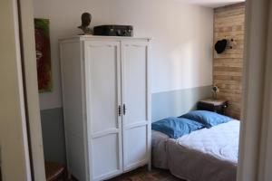 a bedroom with a white cabinet next to a bed at Maison du Lys en Layon in Les Cerqueux-sous-Passavant