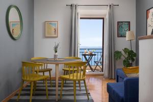 a living room with a table and chairs with a view of the ocean at Beach front Apartment in Podgora