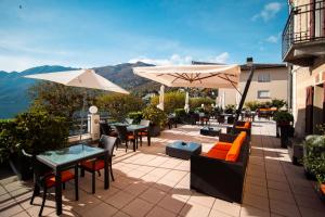 a patio with tables and chairs and umbrellas at Casa al Portico (by La Meridiana) in Ascona