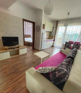 a living room with a couch and a tv at Sunset Sea View Apartament in Mamaia