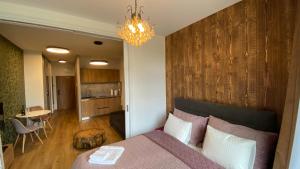a bedroom with a bed with a wooden wall at Apartmán C110 v Hrebienok Resort II in Smokovce +16 photos