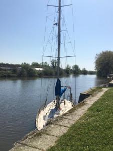a sail boat is docked in the water at La Promenade - Appartement de charme avec vue sur le canal et ses écluses - Centre historique in Redon +7 photos