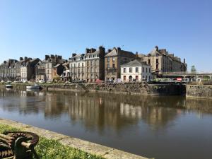 a bench sitting next to a river with buildings at La Promenade - Appartement de charme avec vue sur le canal et ses écluses - Centre historique in Redon