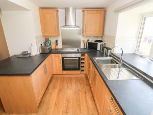 a kitchen with wooden cabinets and a black counter top at Bryngwyn in Haverfordwest