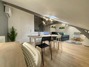 a dining room and living room with a table and chairs at LE MOBILE - Climatisé - Proche de la gare - Centre ville-PROPERTY RENTAL NM in Périgueux