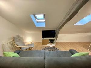 - un salon avec un canapé et une télévision dans l'établissement LE MOBILE - Climatisé - Proche de la gare - Centre ville-PROPERTY RENTAL NM, à Périgueux