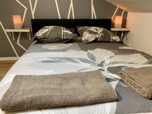 a bed with a blanket and pillows on it at LE MOBILE - Climatisé - Proche de la gare - Centre ville-PROPERTY RENTAL NM in Périgueux