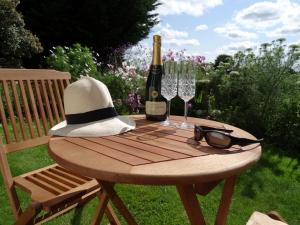 uma mesa de piquenique com uma garrafa de vinho e copos em Pengelly Farmhouse B&B em Truro