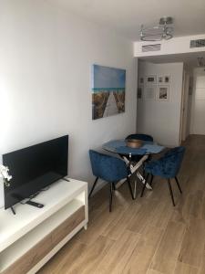 a living room with a tv and a table with chairs at La Rosa Apartment Los Boliches Fuengirola Malaga Spain in Fuengirola