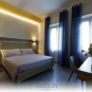 a bedroom with a bed and a chair and windows at GREEN RIBBON in Milan