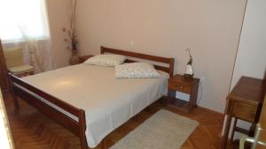 a bedroom with a bed and a night stand and a table at Apartment in Palit with Terrace, Air conditioning, Wi-Fi (4603-1) in Mundanije