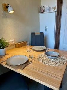 una mesa de madera con dos platos y vasos. en Ferienwohnung Berta Lüneburg, en Lüneburg