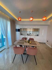 a dining room with a table and two chairs at APARTAMENT De LUX ZEV MEDITERANEO in Mamaia Sat/Năvodari