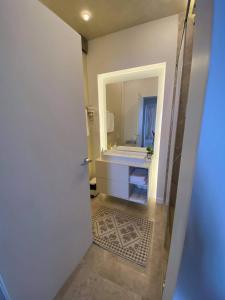 La salle de bains est pourvue d'un lavabo et d'un miroir. dans l'établissement APARTAMENT De LUX ZEV MEDITERANEO, à Mamaia Nord – Năvodari