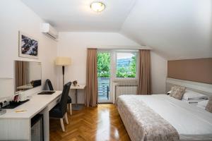 a hotel room with a bed and a desk and a window at Rooms Degenija Annex in Seliste Dreznicko