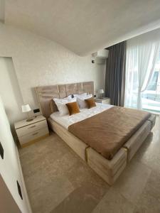 a bedroom with a large bed and a large window at APARTAMENT De LUX ZEV MEDITERANEO in Mamaia Sat/Năvodari