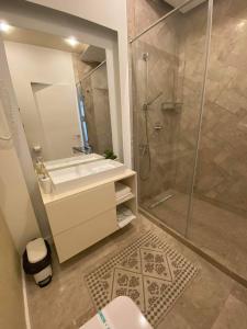 a bathroom with a sink and a shower at APARTAMENT De LUX ZEV MEDITERANEO in Mamaia Sat/Năvodari