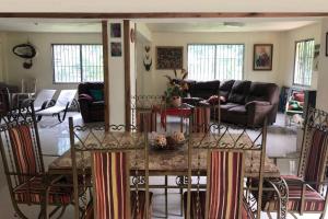 cocina y sala de estar con mesa y sillas en Acogedora Casa Rural en plena naturaleza frente al Río con piscina Bonao en Bonao