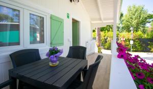 un tavolo nero e sedie su un portico fiorito di Camping Parco Vacanza Partaccia 2 a Marina di Massa
