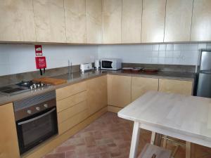 a kitchen with a stove and a table in it at Casa Algarbe in Faro