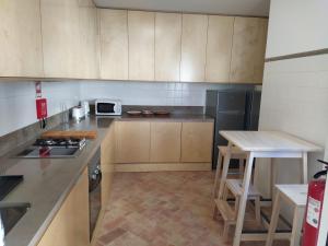 uma cozinha com armários de madeira e uma bancada em Casa Algarbe em Faro