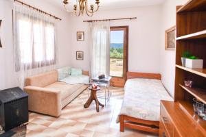 un soggiorno con un divano e un tavolo di Vast Emerald, the only house in Kavourotrypes a Sárti