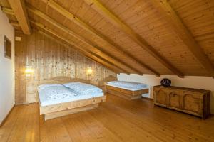 2 camas en una habitación con techo de madera en Ferienwohnung Sonnenblume Nusserhof en Avelengo