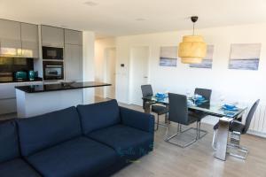 a living room with a blue couch and a table at AgrellaMar - by TonsdeVerde in Braga