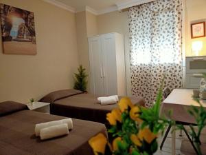 a small room with two beds and flowers in it at Casa Rural Vacacional in Puerto Real +15 photos