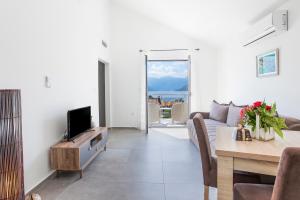 a living room with a couch and a tv and a table at Apartments Stetonn in Kotor
