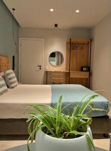 een slaapkamer met een bed en een potplant bij George Deluxe Apartments in Stalida